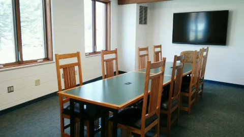 Classroom with 2 tables, 8 chairs, and large display screen