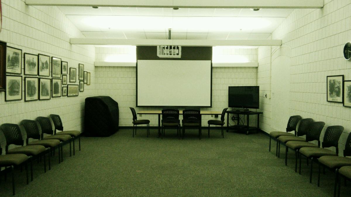 Meeting room with large screen and chairs
